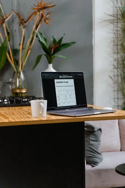 A modern workspace showing hands analyzing marketing data on a laptop and paper documents.